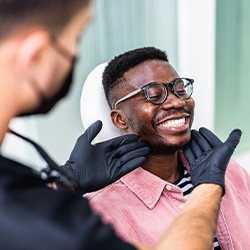 Dentist looking at patient's smile in treatment room