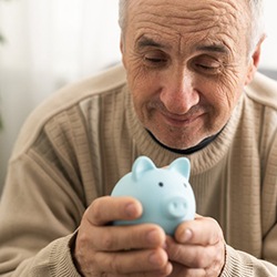 Man holding a small blue piggy bank