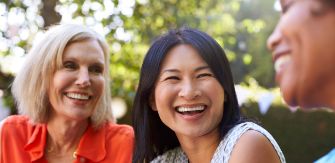Three women laughing together outdoors