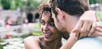Young man and woman hugging each other outdoors