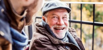 Senior man in hat and scarf smiling