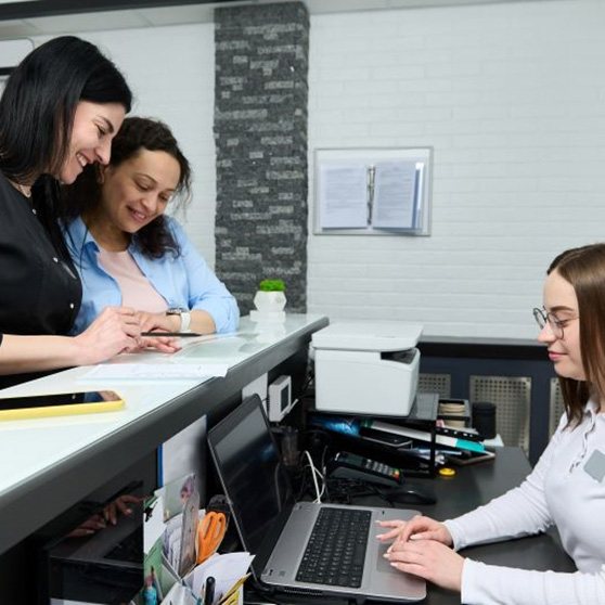 Dental team member assisting patients at front desk