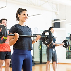Smiling woman lifting weights in workout class