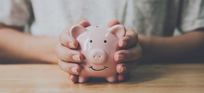 Person holding a pink piggy bank