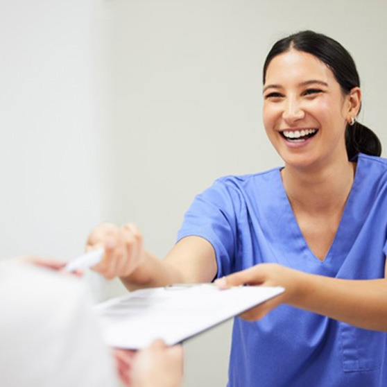 Dentist handing a patient her dental insurance form