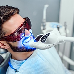 Man having teeth whitened in office